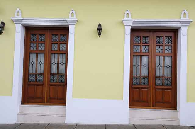 Photo example of color combinations on different house styles in this picture a classic looking combination of a light pastel yellow color on the walls with white frames and wooden doors