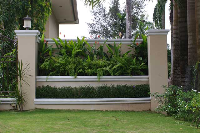  Photo Example of a decorative fence or separator made of a cement wall with 2 steps including a small garden area