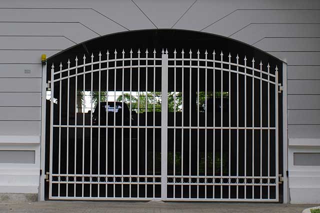 Photo of a simple white security metal gate in front of a city building