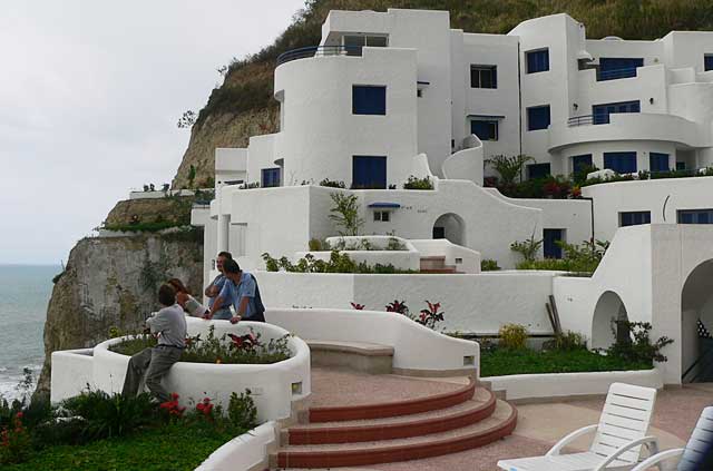 Photo example of a modern apartment complex painted in white in combination with deep blue, at a top location, overlooking the Pacific Ocean