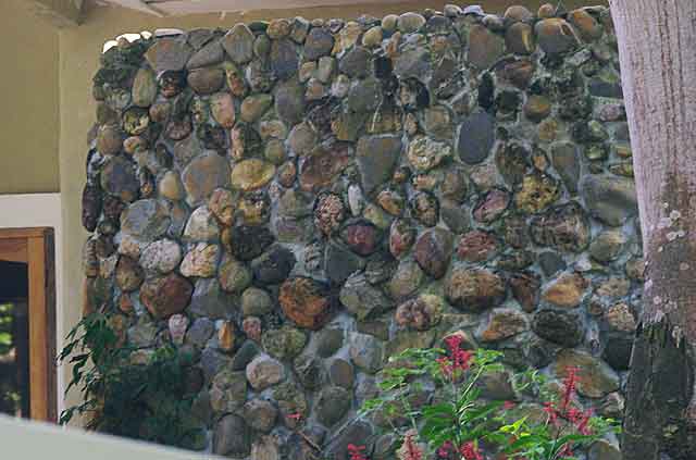 Photo example of a wall on country house built with local grey and redish river stones